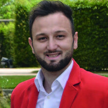 Portraitfoto von Hasim Celik in rotem Sakko.