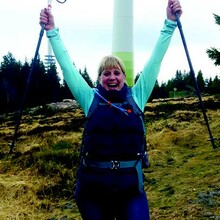 Kim Früh hält zwei Nordic Walking Stöcke in die Luft. 