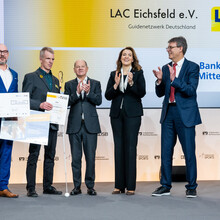 Die Vereinsvertreter des LAC Eichsfeld nehmen den ersten Preis von Olaf Scholz, Marija Kolak und Thomas Weikert entgegen.