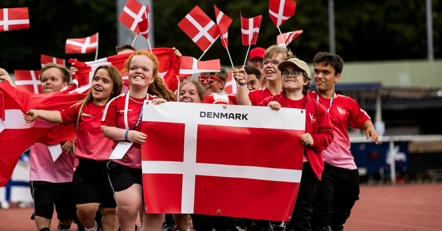 Die dänische Nationalmannschaft beim Einlaufen mit Flaggen in Groß und Klein